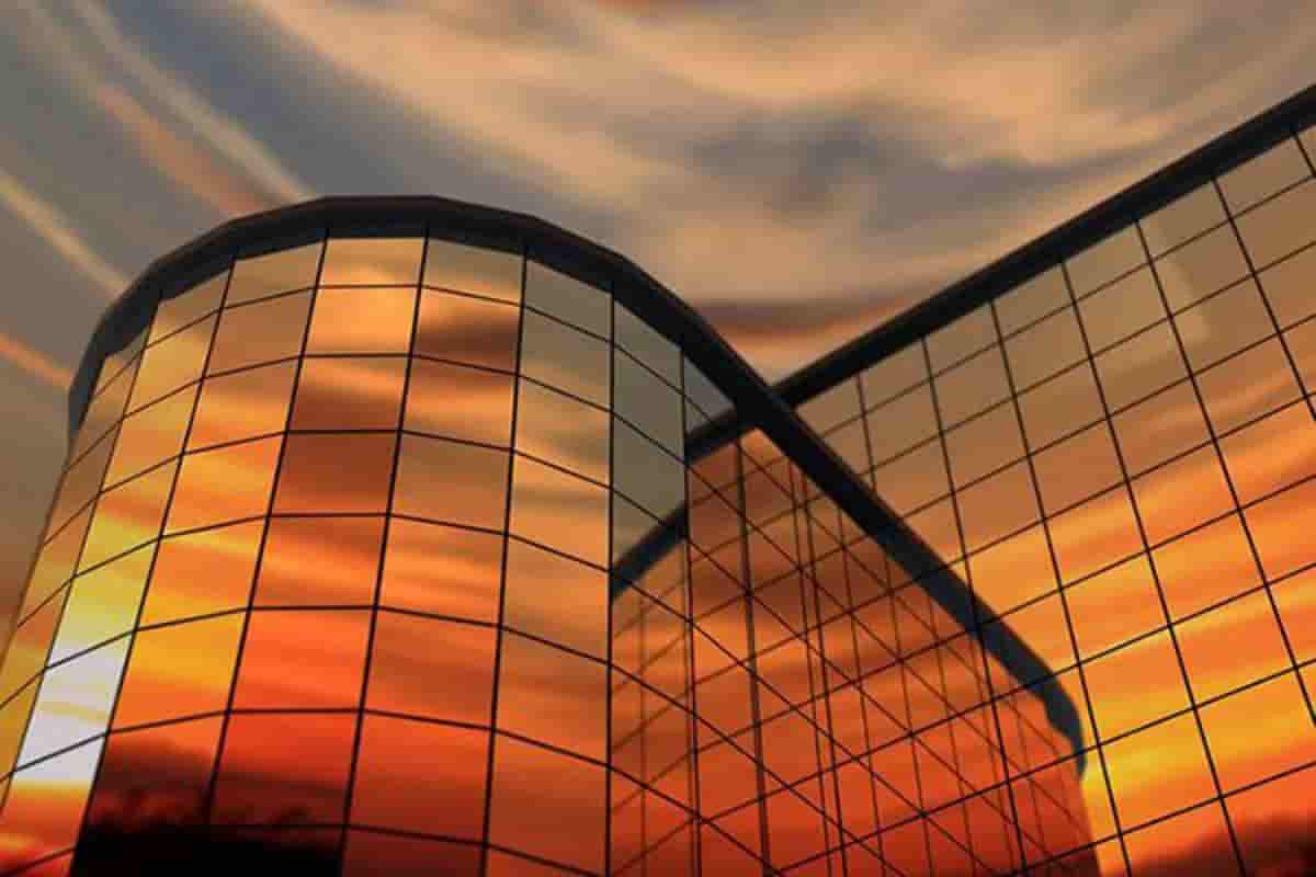 نمای کرتین وال ساختمانی که غروب آفتاب را در خود منعکس کرده است